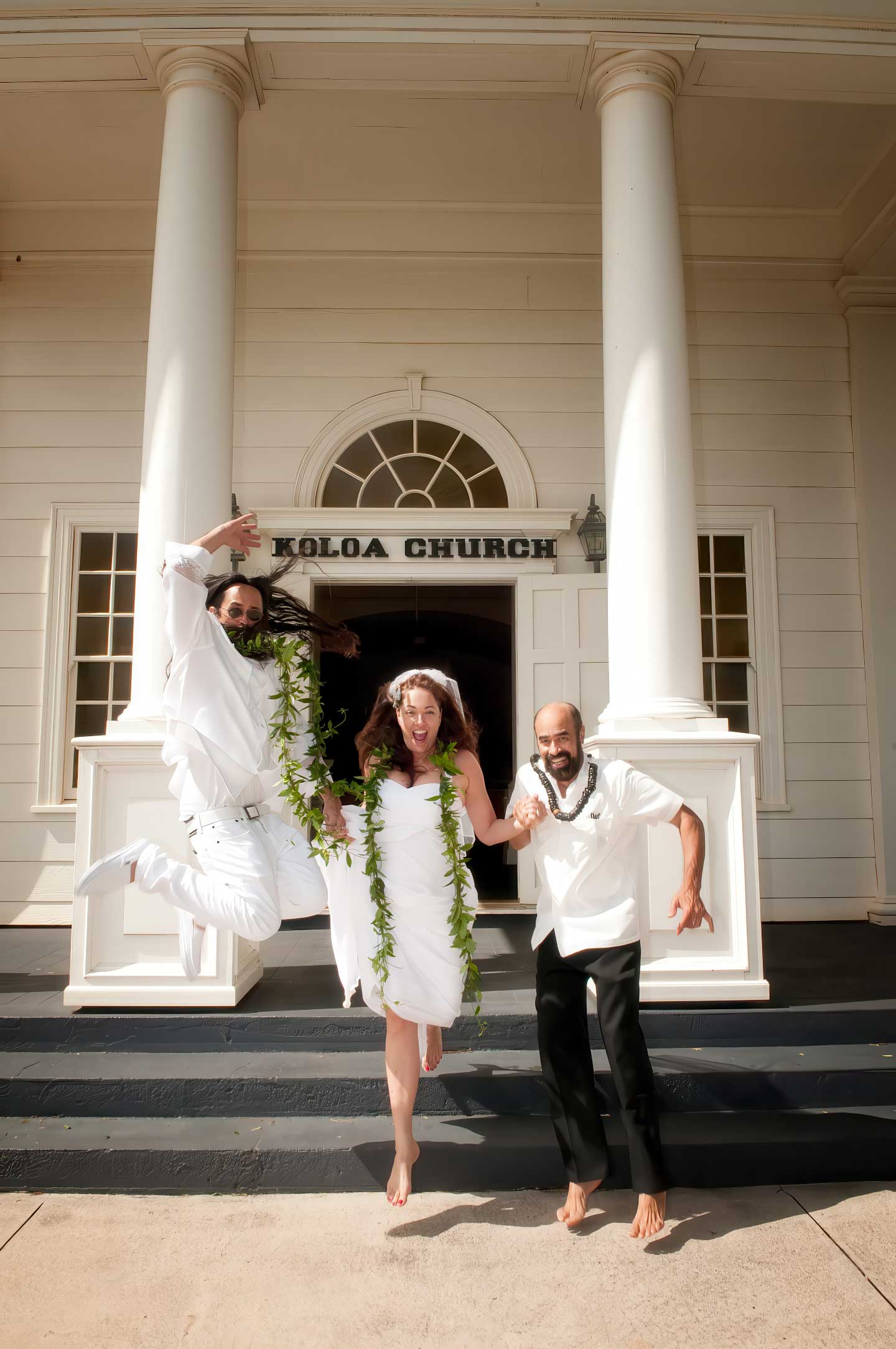Joyful wedding couple and Pastor Kilborn celebrate their Kauai South Shore ceremony at historic Koloa Church