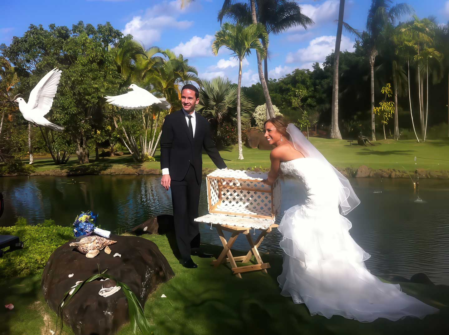 Bride and groom releasing doves over a garden pond during a wedding with Kauai South Shore Weddings and Pastor Kilborn.